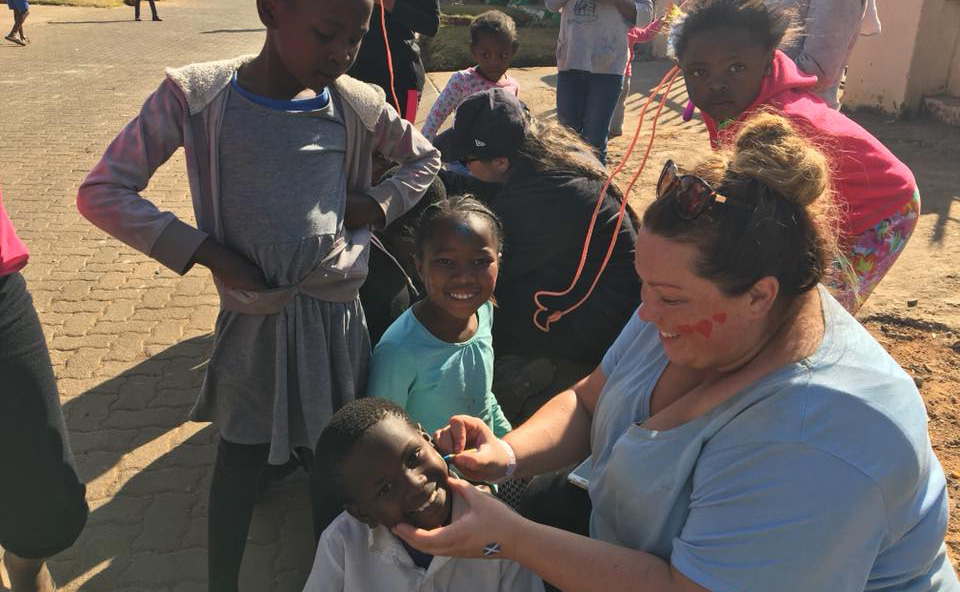 Applying face paints of the South African and Scottish flags.