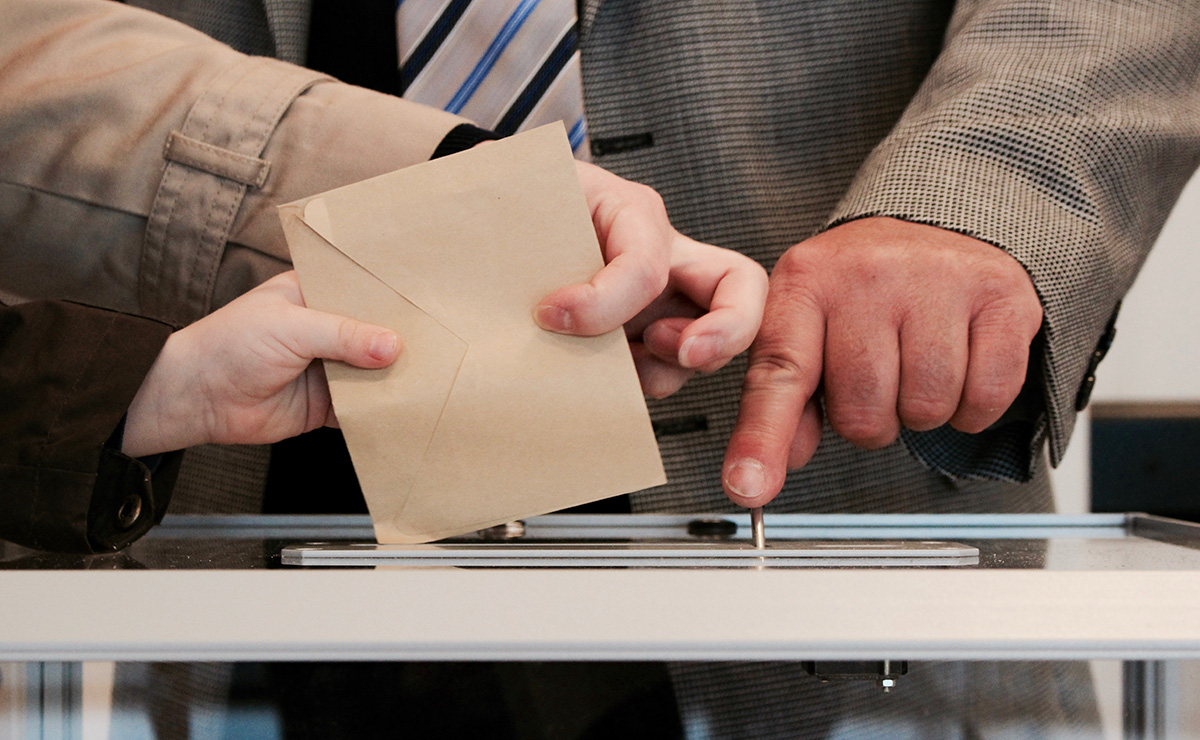 People casting their vote in a polling box