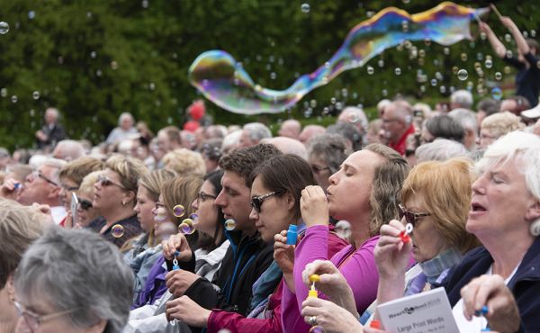 Attendees blowing bubbles in Princes Street Gardens at a previous event