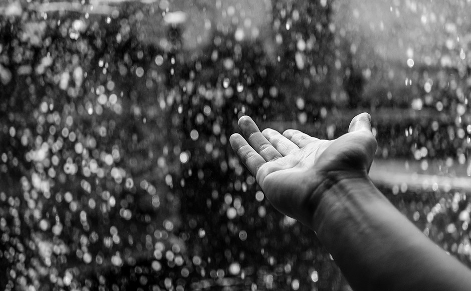hand reaching out into rain