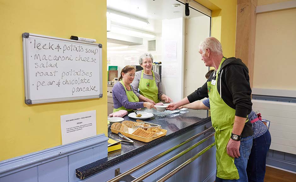 People at a church kitchen preparing to hand out food      