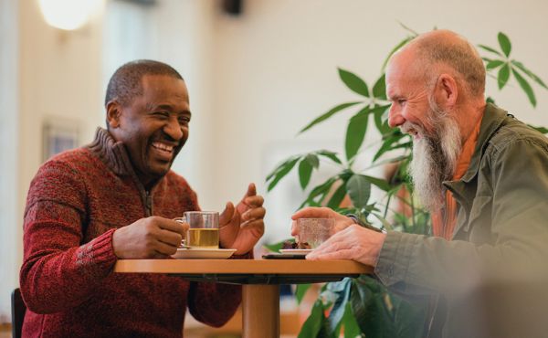 Two men talking and laughing at a table