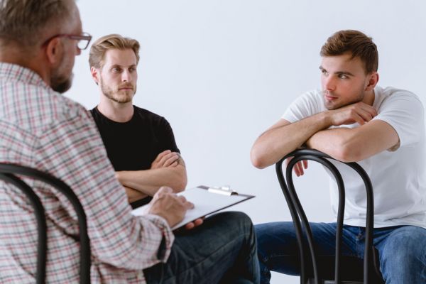 Men in deep discussion during an all male workshop