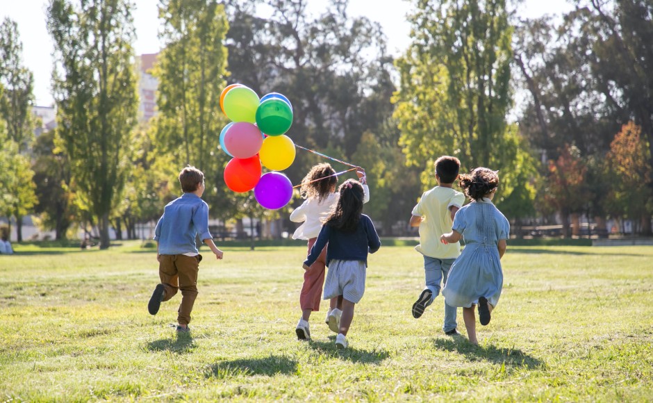 Children running holding balloons