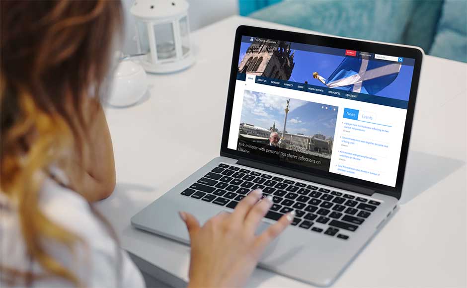 Woman working on computer with the Church of Scotland website on the screen