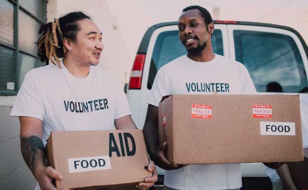 Two men holding boxes of food aid
