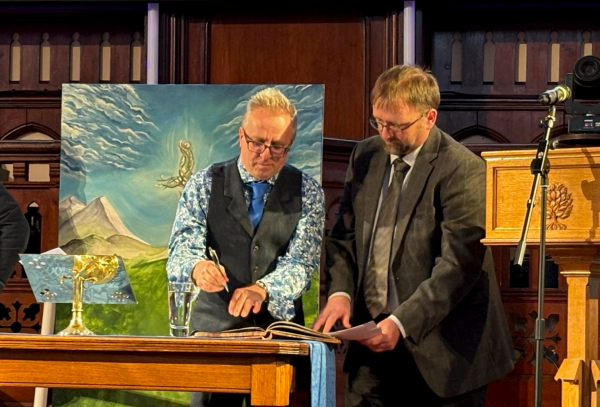 Rev Tim Linford signs his ordination papers