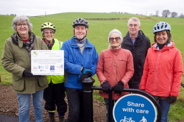 Supporters of the pathway holding up a sign recognising the Church of Scotland's contribution.