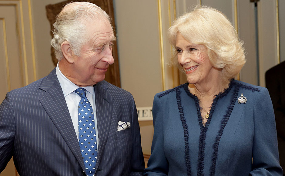 King Charles and Queen Camilla smiling at each other