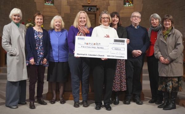 A photo of Blackhall St Columba's passing a cheque on to HopScotch