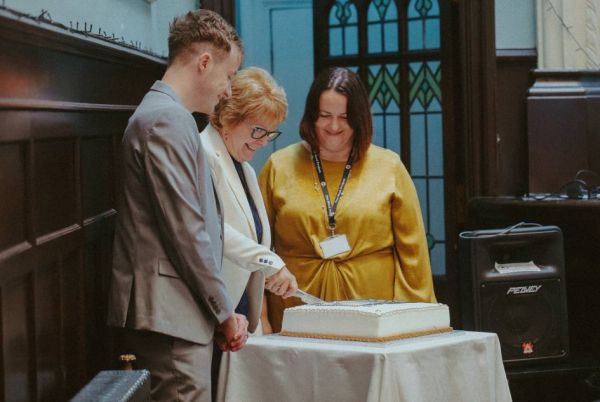 Shed Youth & Schools Manager Matthew MacNeil, Shed Chairperson Christeen MacDonald and Shed Community Manager Fiona Douglas cut the anniversary birthday cake.