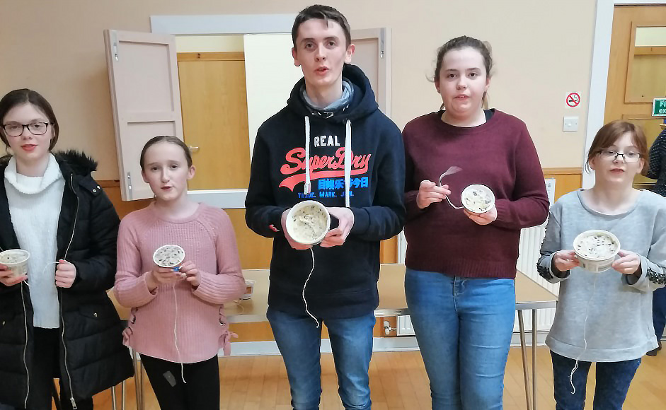 Young church members display the bird feeders