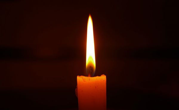 Lit candle in the dark