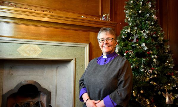 Rt Rev Susan Brown in front of Christmas tree