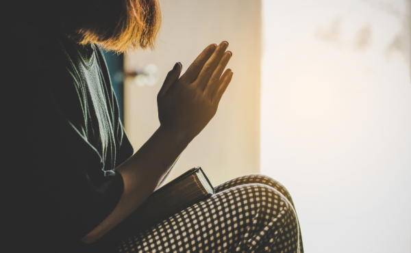 Woman praying with a Bible