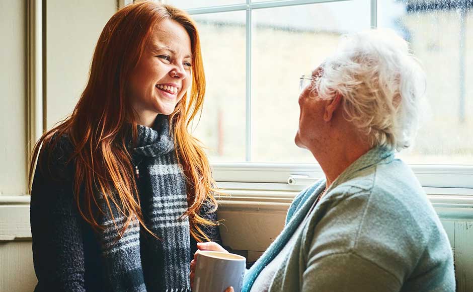 Younger woman and older woman smiling at each other