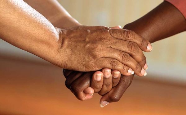 Two women's hands clasped together