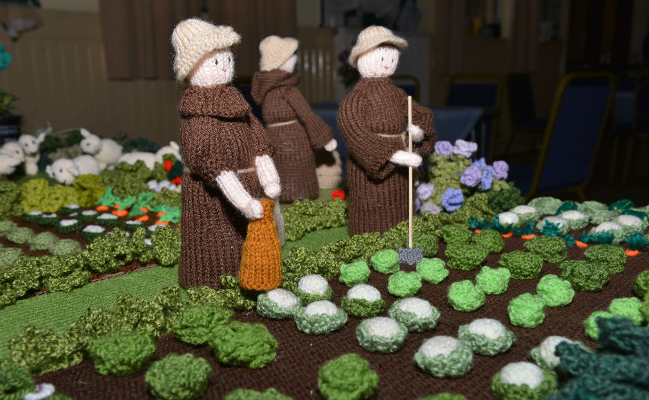 Knitted scenes depicting the daily life of monks and pilgrims. this shows the monks gardening.