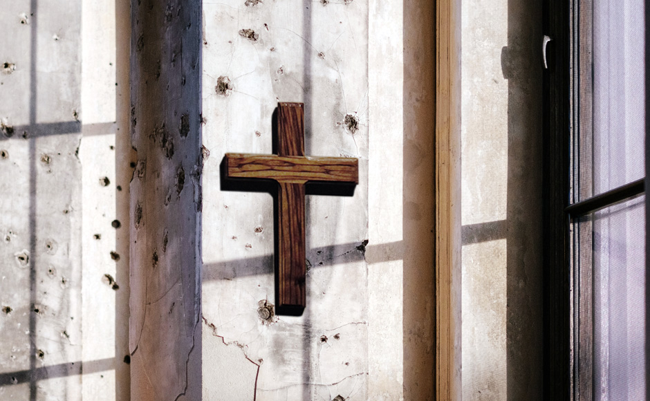 Cross on a wall full of bullet holes