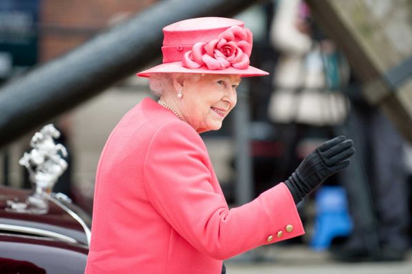 Queen Elizabeth waving, wearing a pink dress and hat