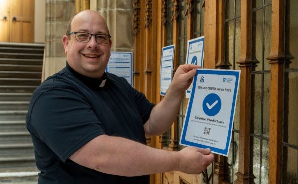 Rev Bryan Kerr, the minister of Greyfriars Parish Church in Lanarkshire, with one of the posters