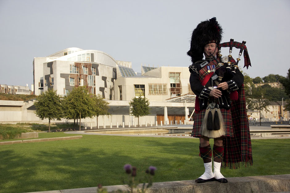 Bagpiper with Scottish Parliament building in the background