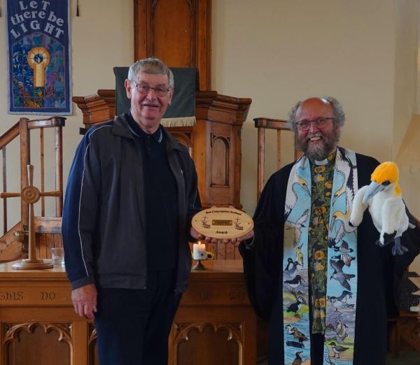 Westray Church's Alasdair McVicar accepts the Eco-Congregation Scotland Gold Award from Rev David Coleman
