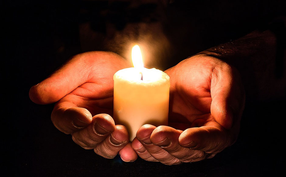 Hands holding a candle