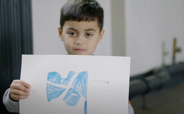 Little boy holding a picture of a Scottish flag