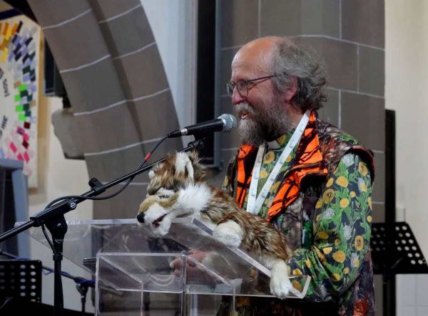 Eco-Congregation Scotland chaplain David Coleman preaching with the help of his wolf puppet.