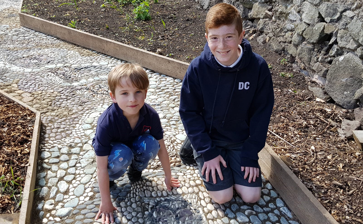 Parsons Green Primary School pupils crouching by the tile they made 