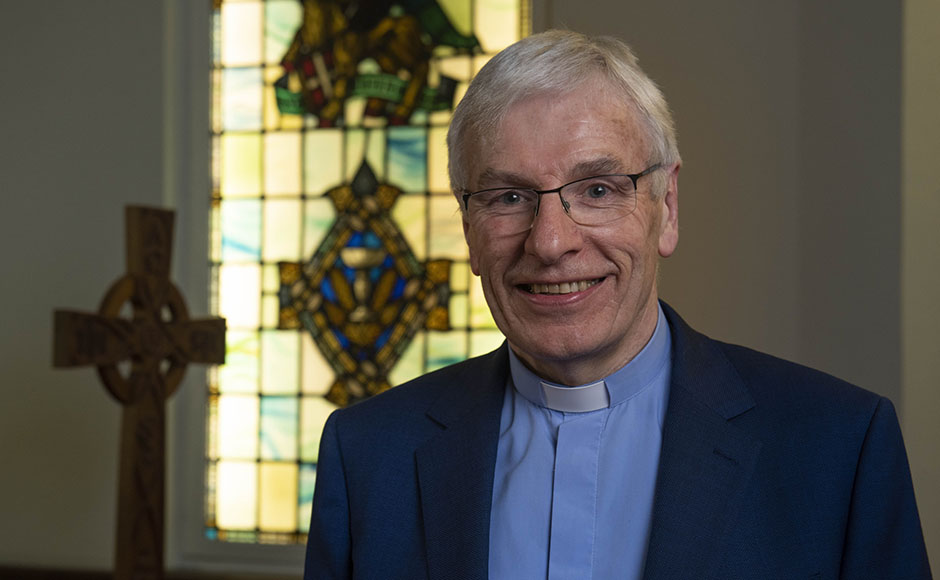 Rt Rev Colin Sinclair in front of a stained glass window