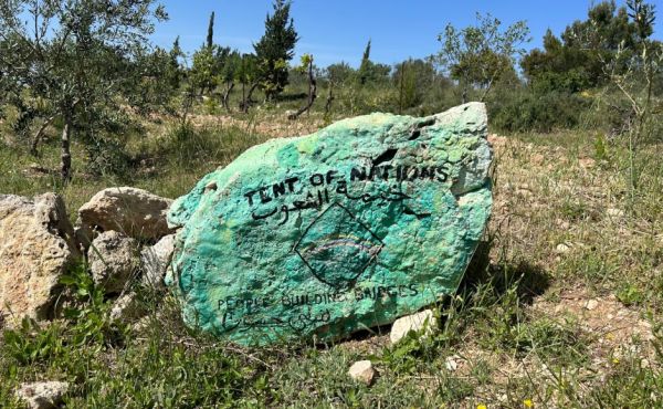 A Tent of Nations sign on a rock